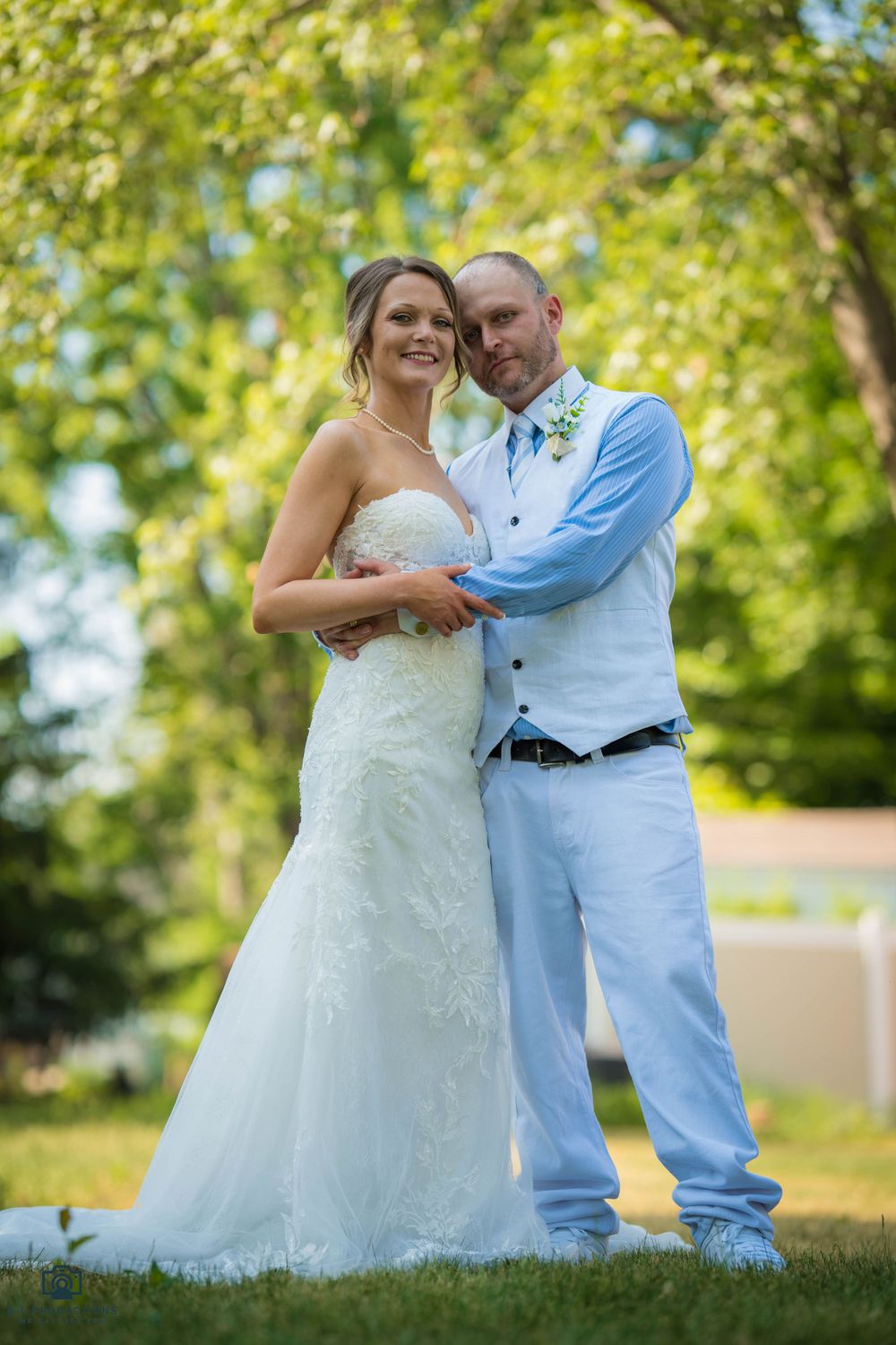 A couple poses together, smiling happily, their love and affection evident in their embrace.