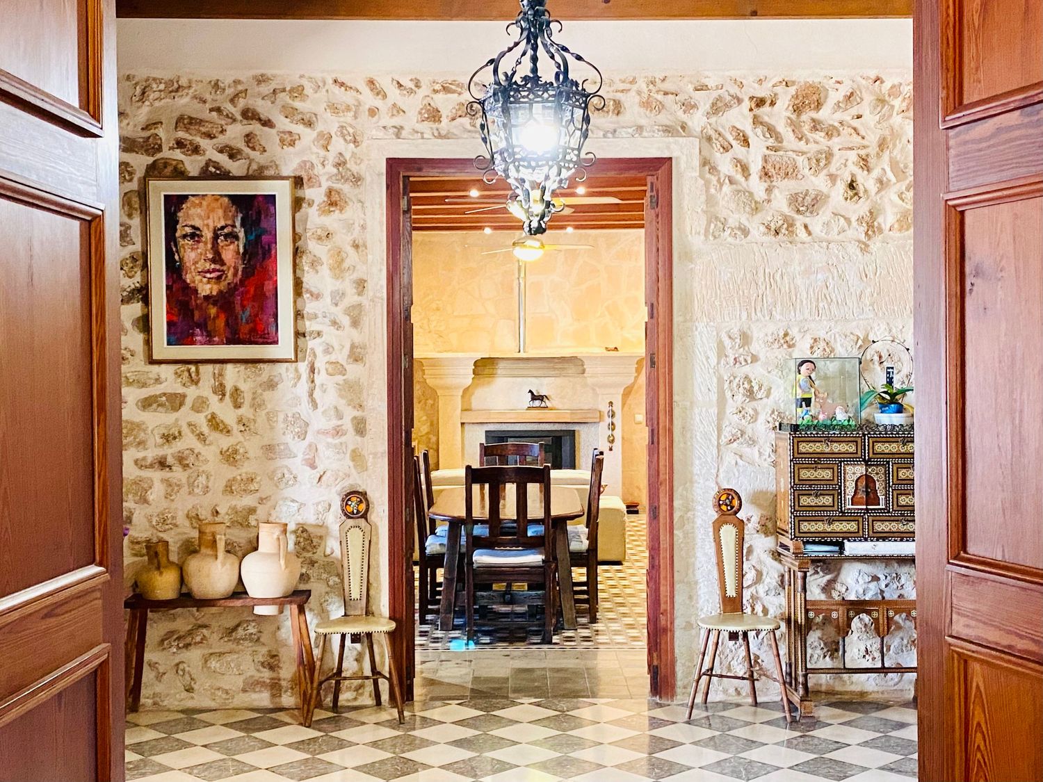 Traditional hallway with stone walls, wooden doors, and decorative lantern pendant light.