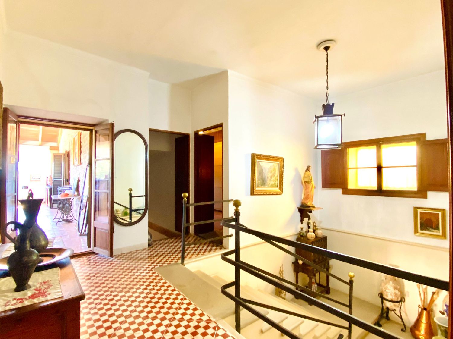 Elegant entryway with checkered floor tiles, vintage furniture, and arched doorways.