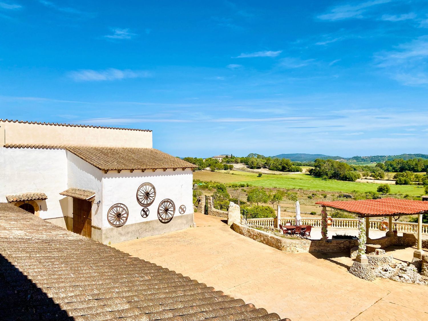 White Mediterranean-style building with outdoor terrace overlooking scenic countryside.