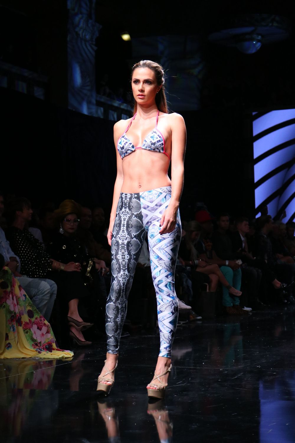 Snake print activewear ensemble featuring matching bikini top and leggings on dark runway.