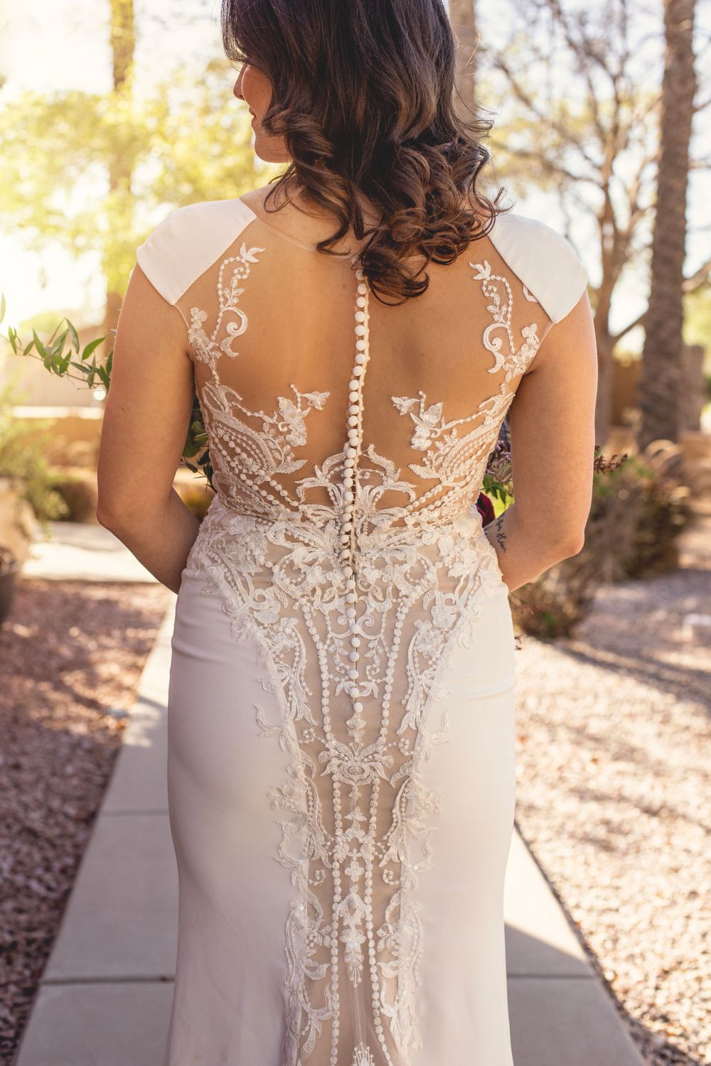 Intricate lace detailing on the back of an elegant white wedding gown.