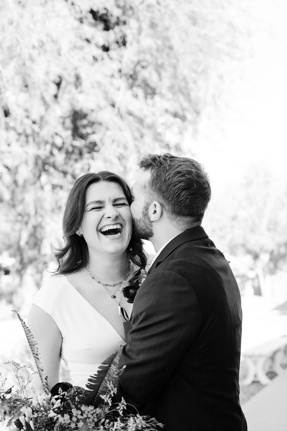 Black and white wedding portrait series capturing joyful laughter and intimate moments.