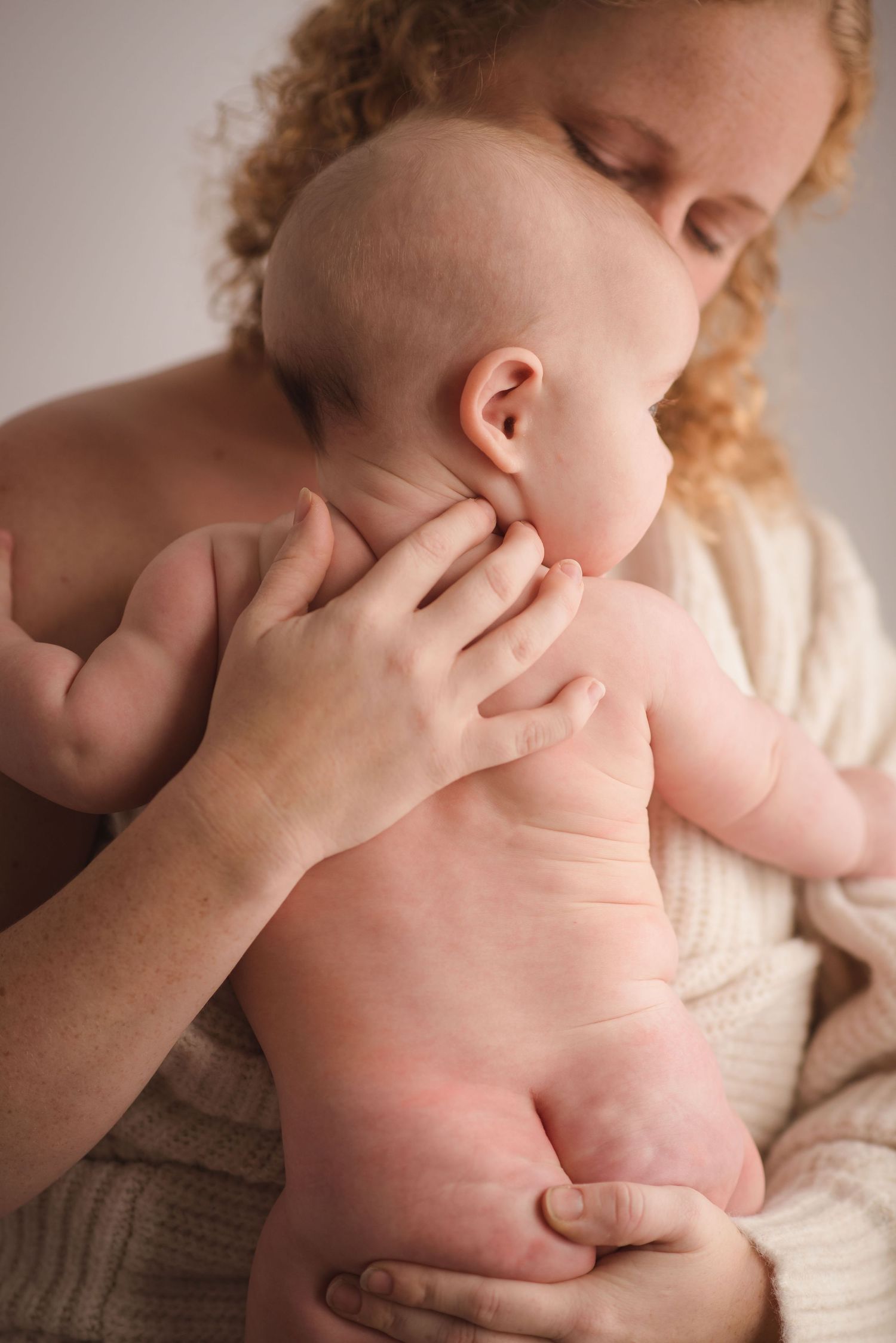 Tender moment between parent and infant in soft natural light.
