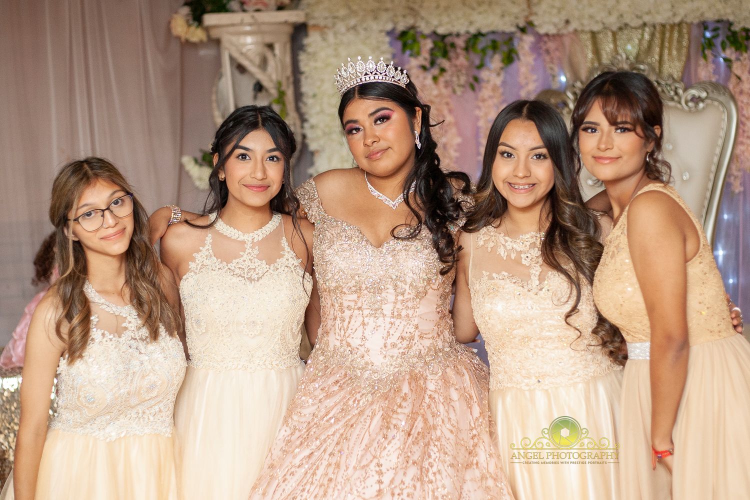 Group photo of attendees in light colored dresses at a formal celebration.