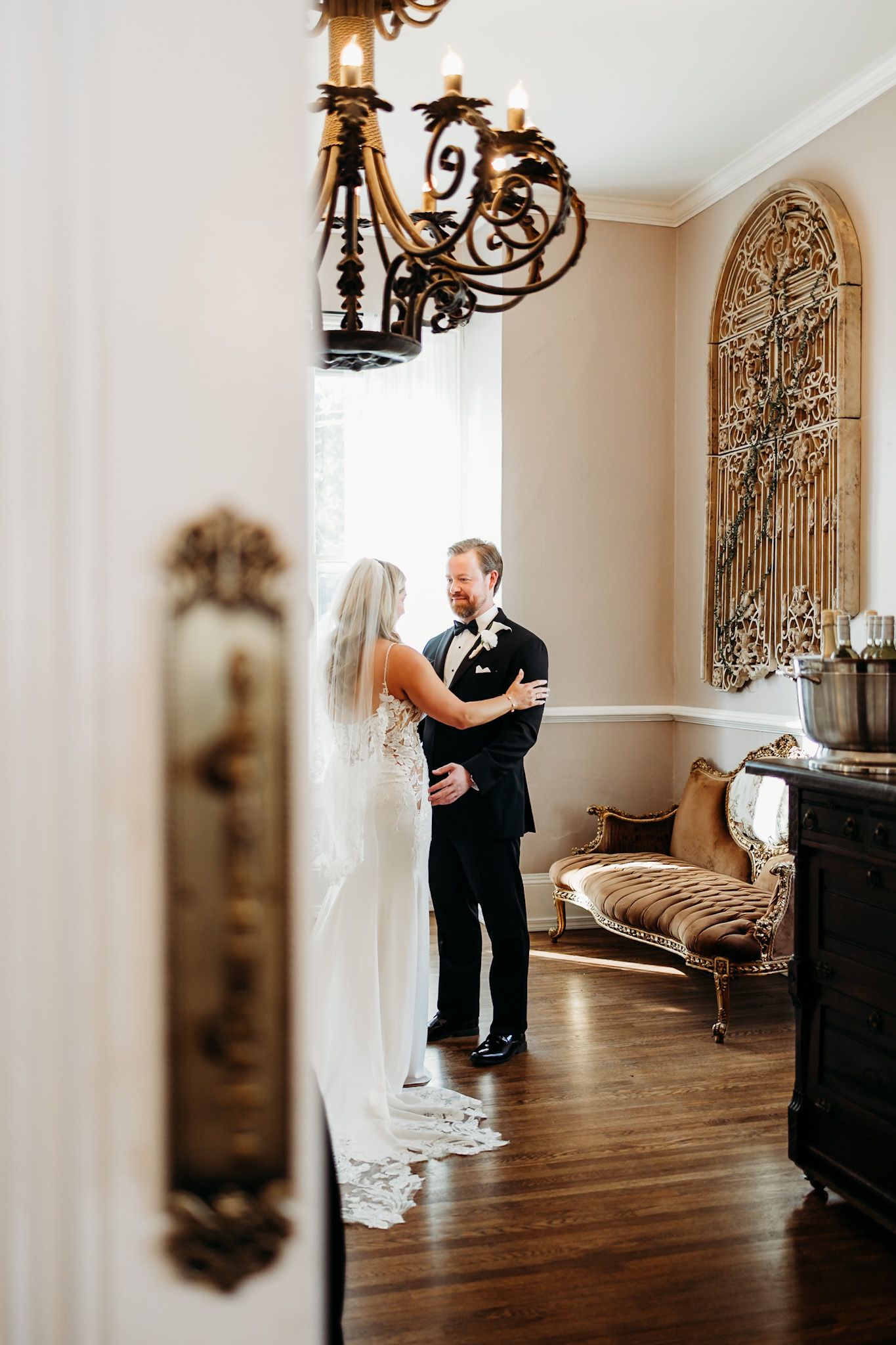 bride and groom doing a first look behind big french doors