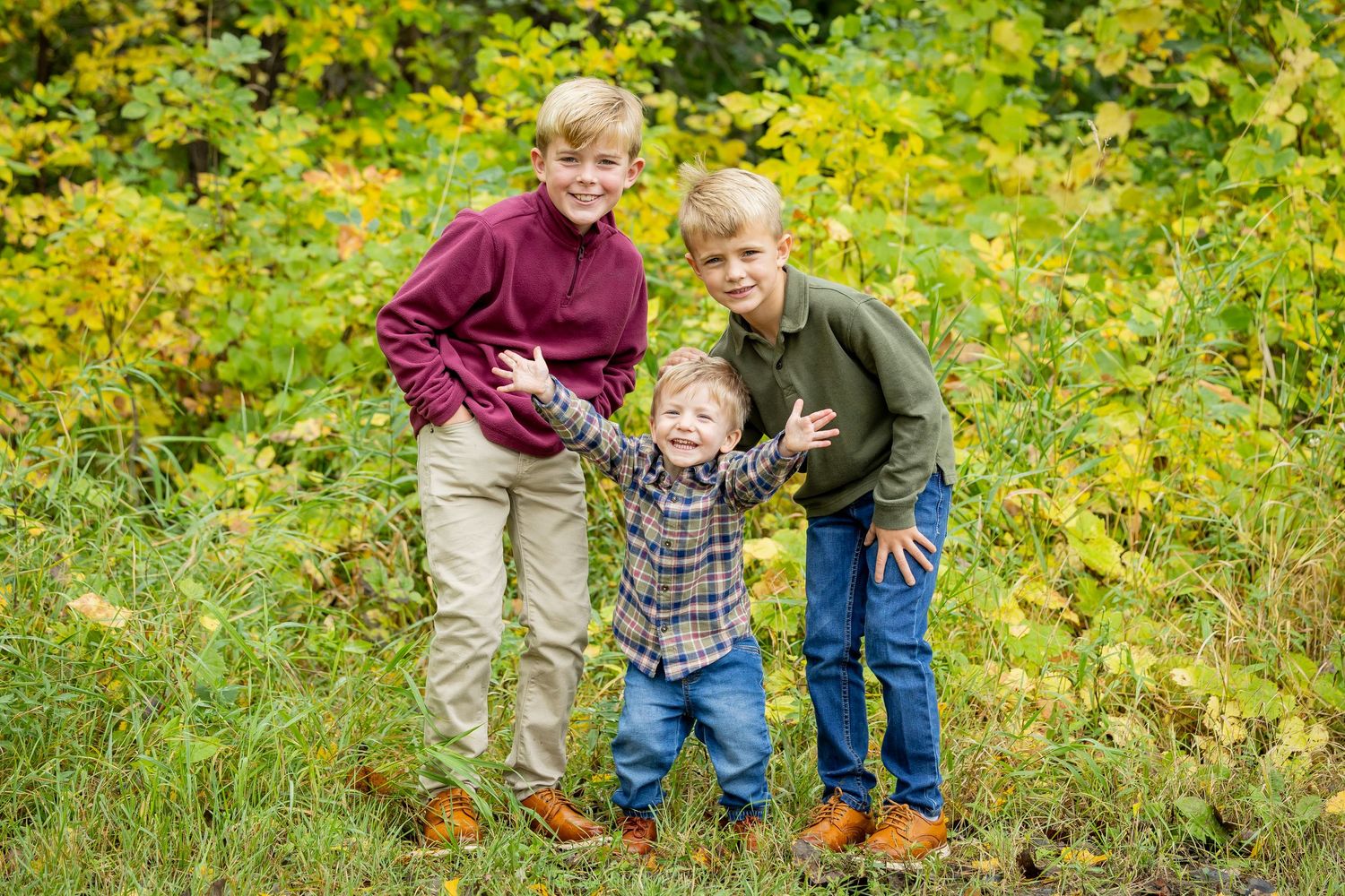 Family photo session in a vibrant yellow and green autumn field setting.