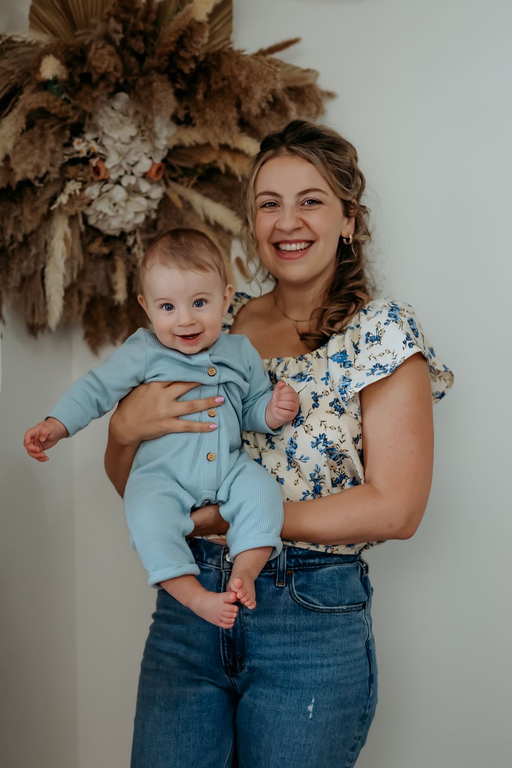 Sweet candid family photos with baby in blue romper and parents in casual denim and floral attire.