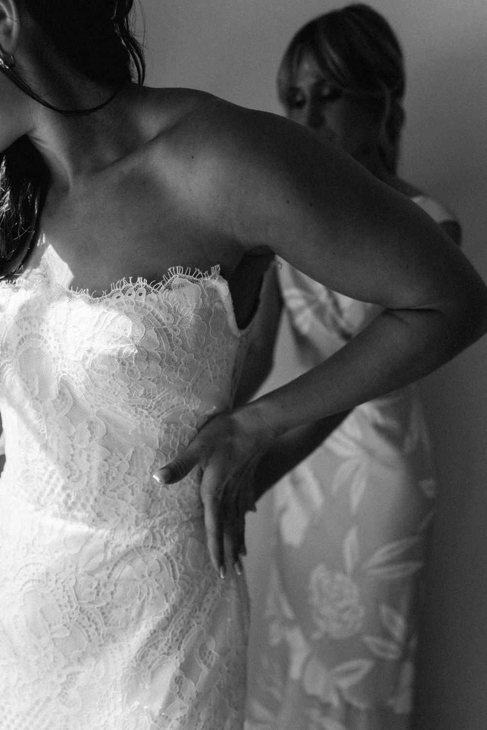 Close-up details of a white lace wedding dress bodice in black and white.