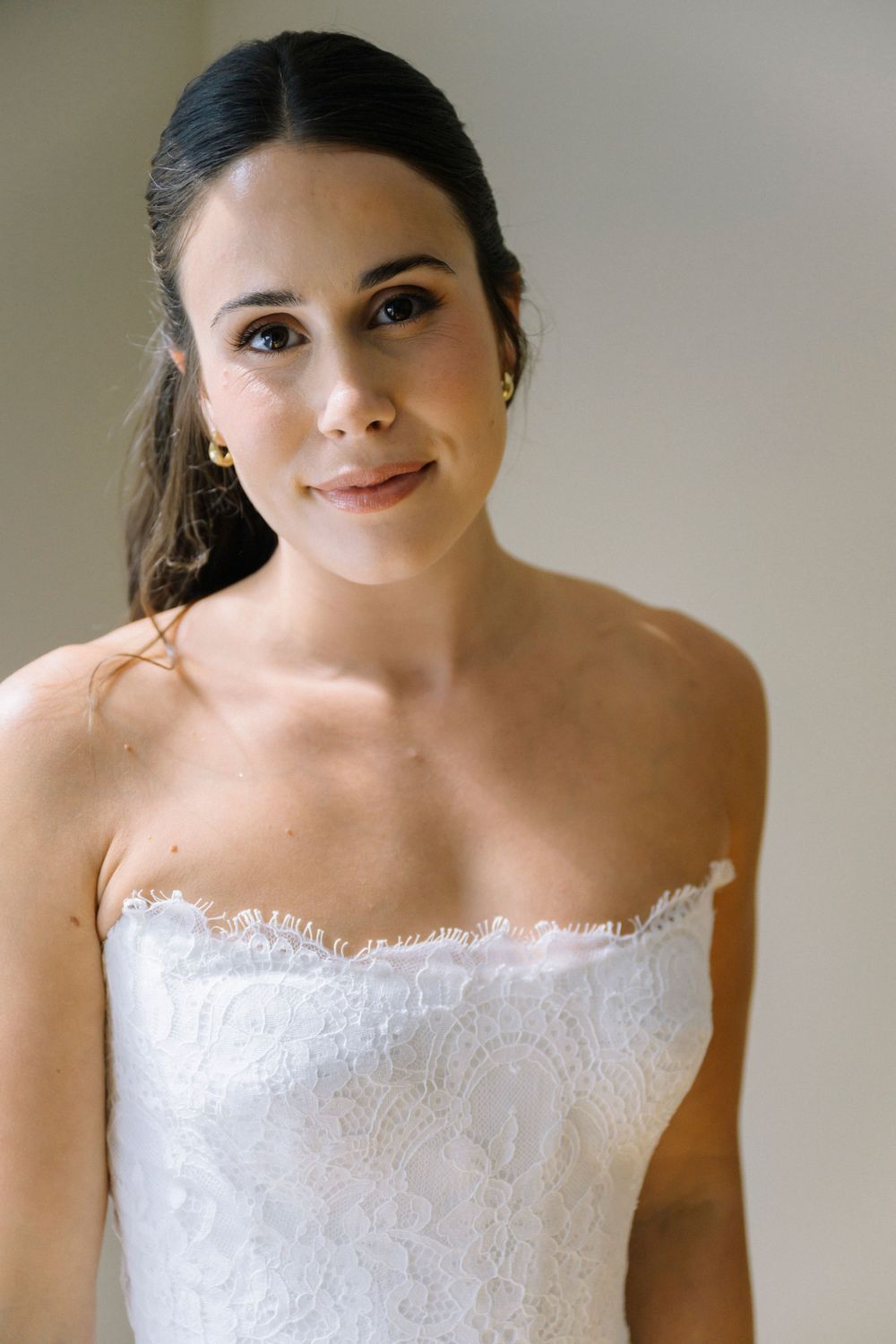 Close-up of delicate white lace trim on strapless wedding dress bodice.