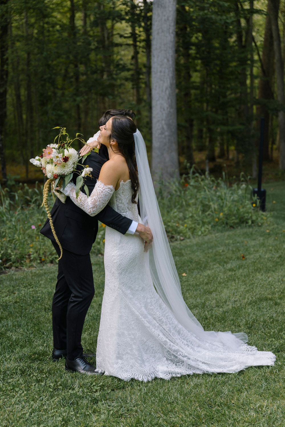 Wedding couple sharing a romantic moment in a wooded outdoor ceremony setting.