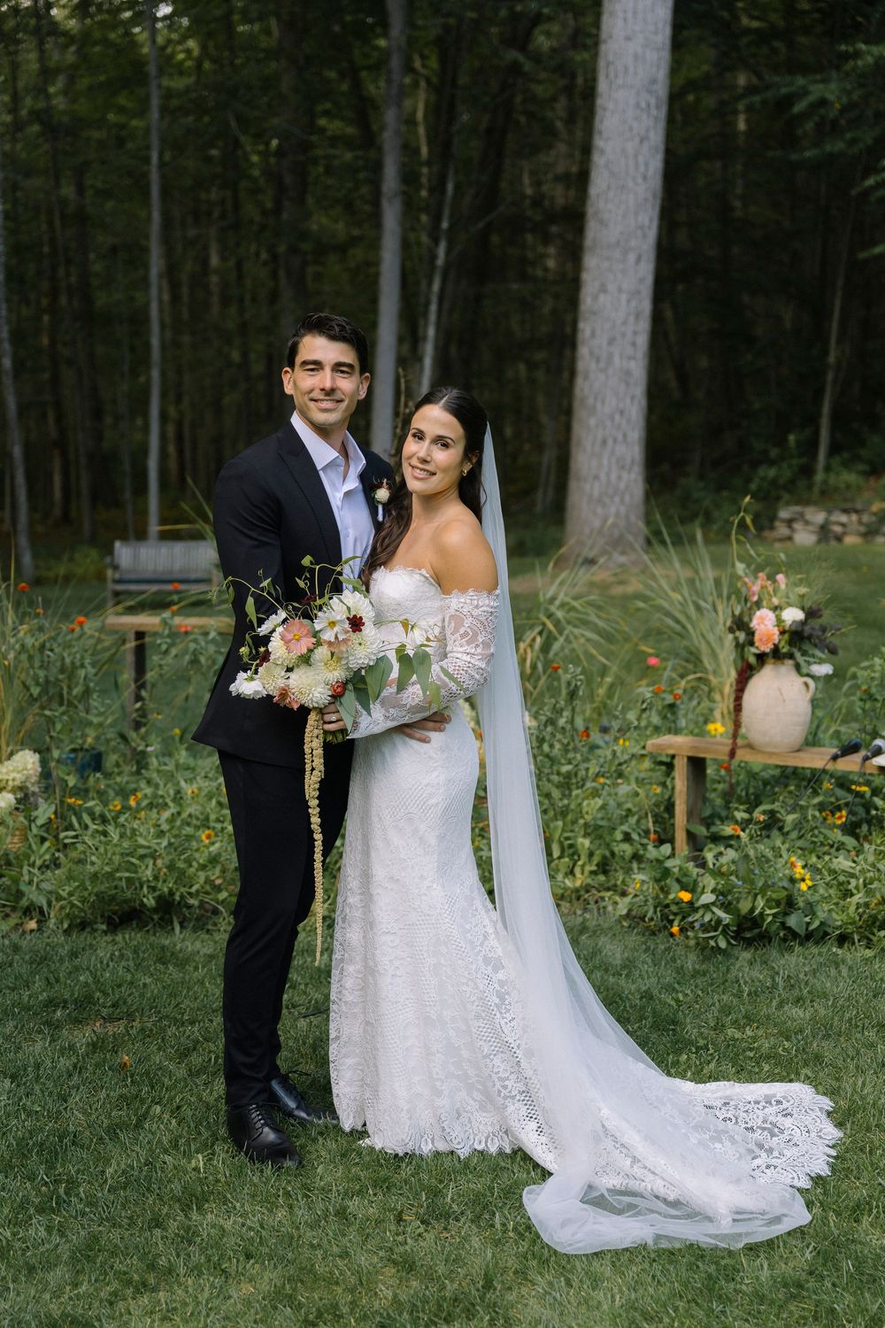 Elegant wedding portraits captured in a wooded garden setting with natural light and floral arrangements.