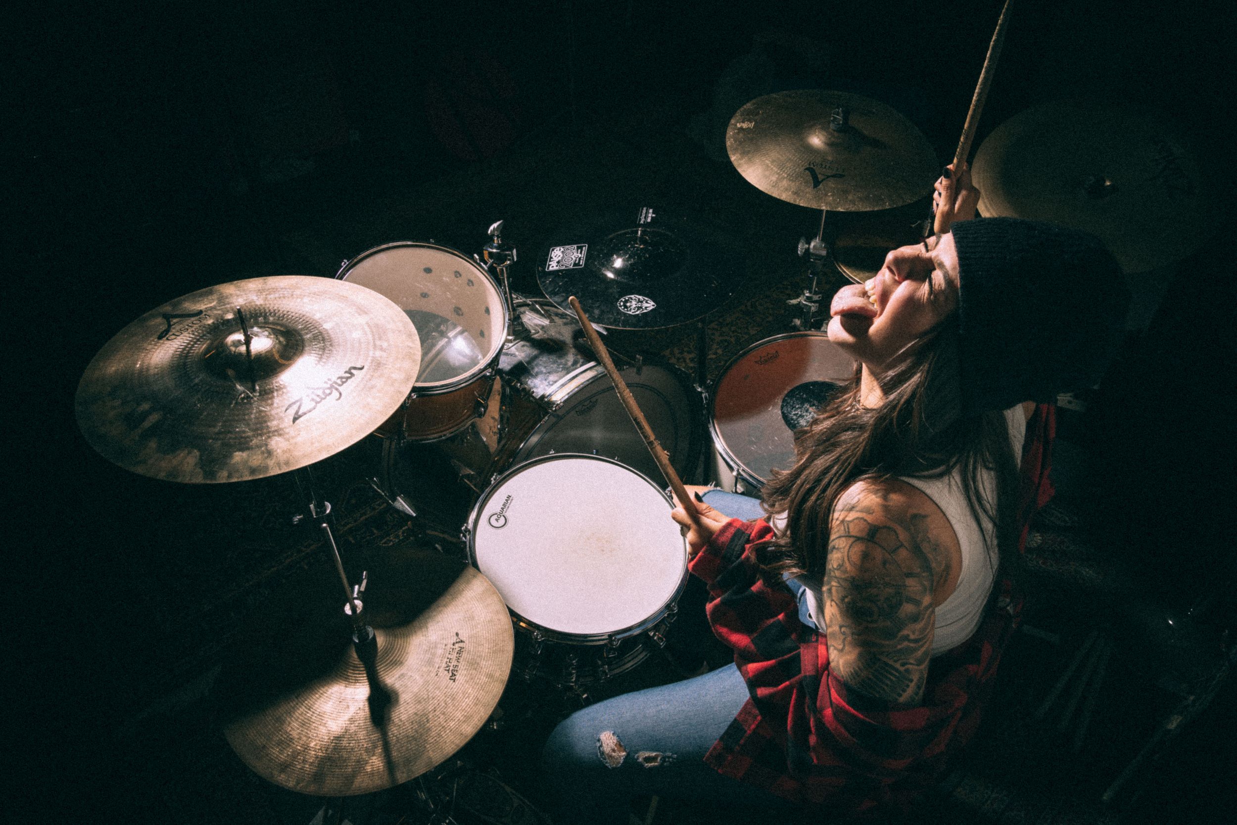 Overhead shot of drummer performing on stage with illuminated drum kit.