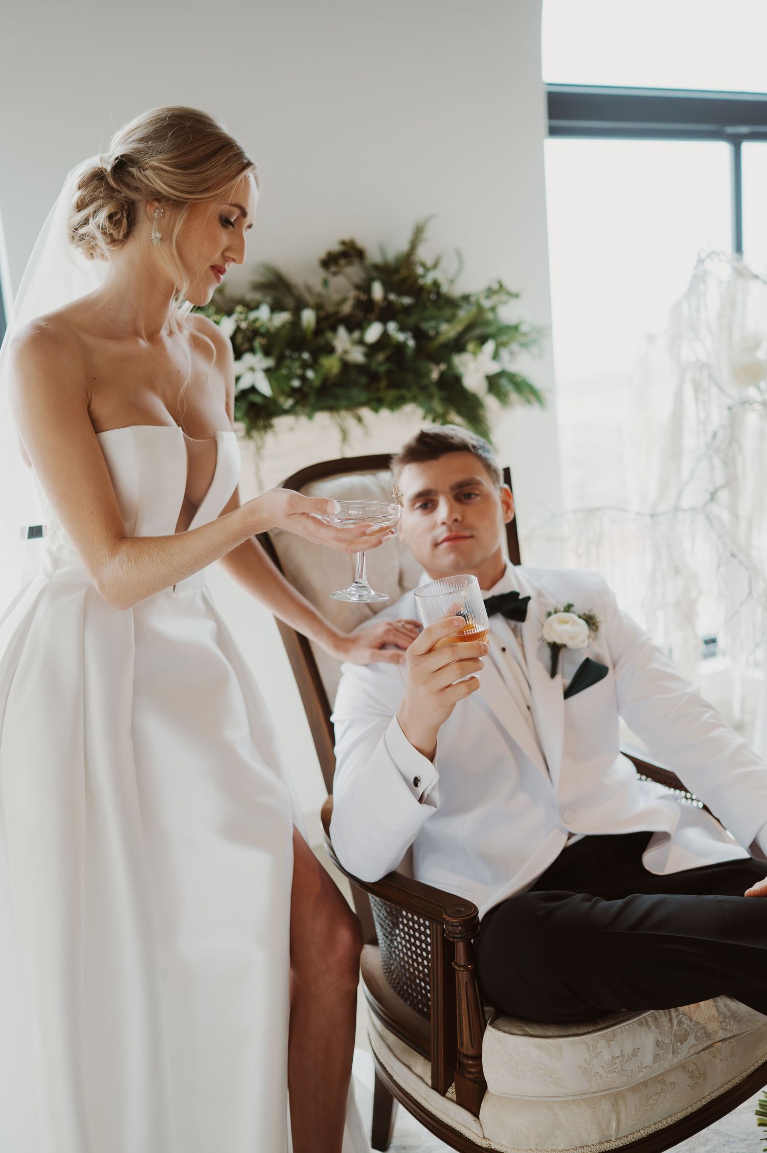 Romantic wedding moment with couple sharing intimate kiss as bride holds floral bouquet on their special day.