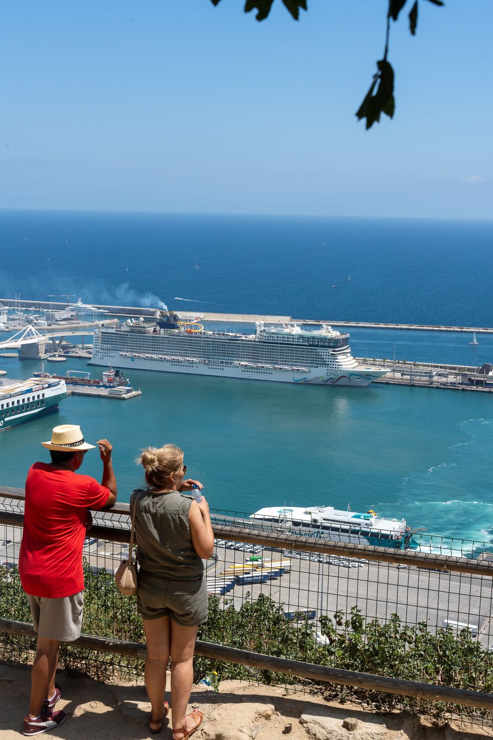 Cruise ship docked in Barcelona port with scenic Mediterranean Sea view.