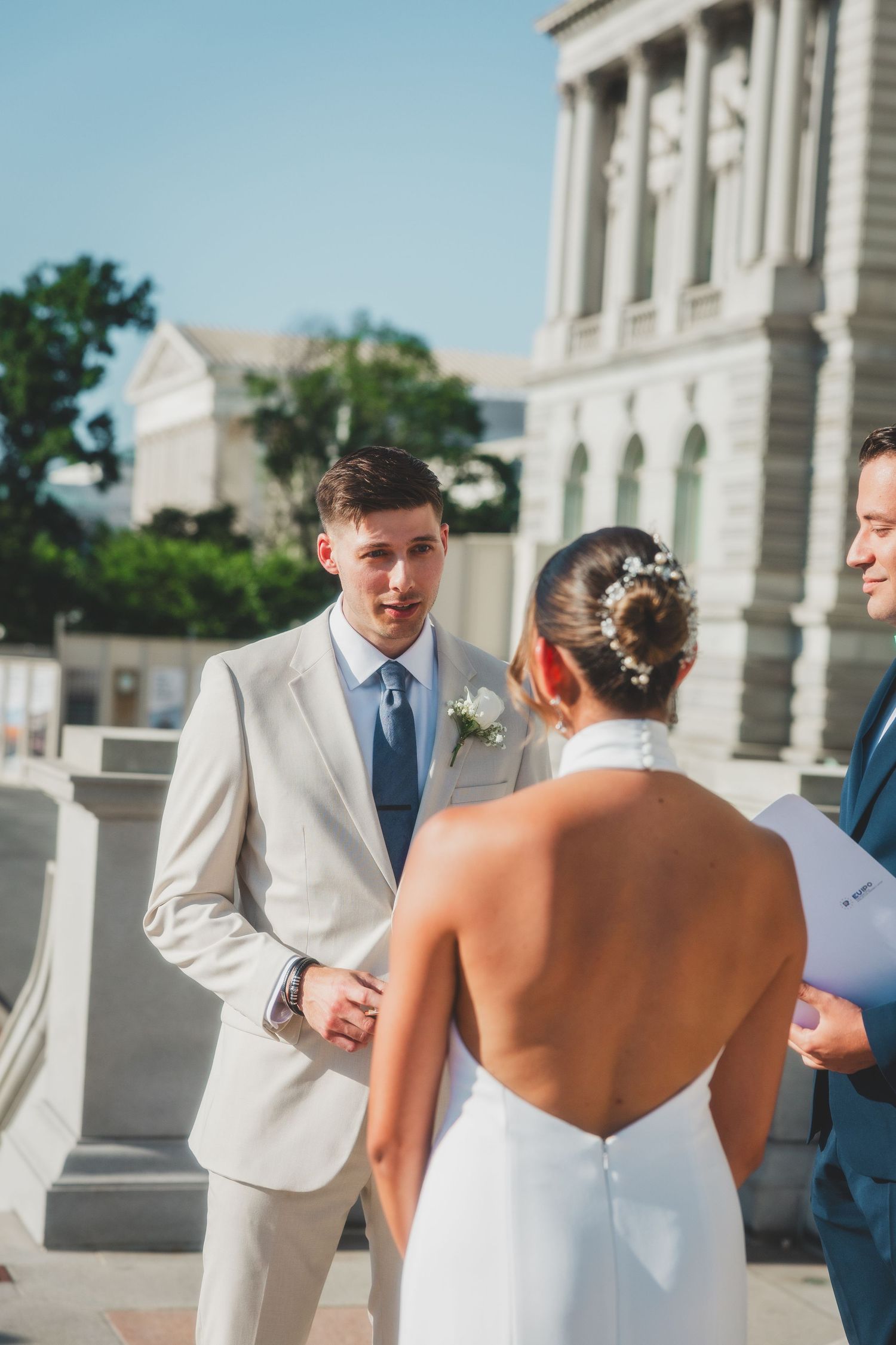 An intimate wedding ceremony moment captured on grand marble steps of a historic building.