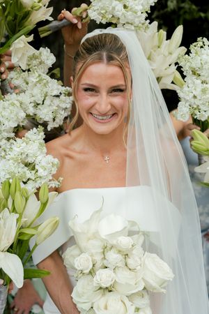 Bridal portraits featuring white floral arrangements and a flowing veil against a dark background.