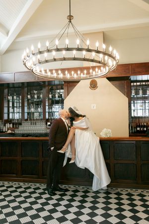 Ballroom dance scene with circular chandelier and black and white checkered floor.
