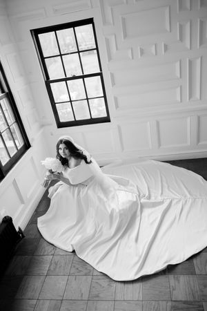 A sequence of black and white photos shows a figure in flowing white fabric lying on a tiled floor near a window.