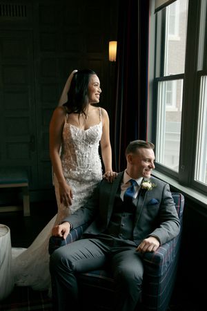 Intimate indoor portrait session with dramatic window lighting and dark interior.