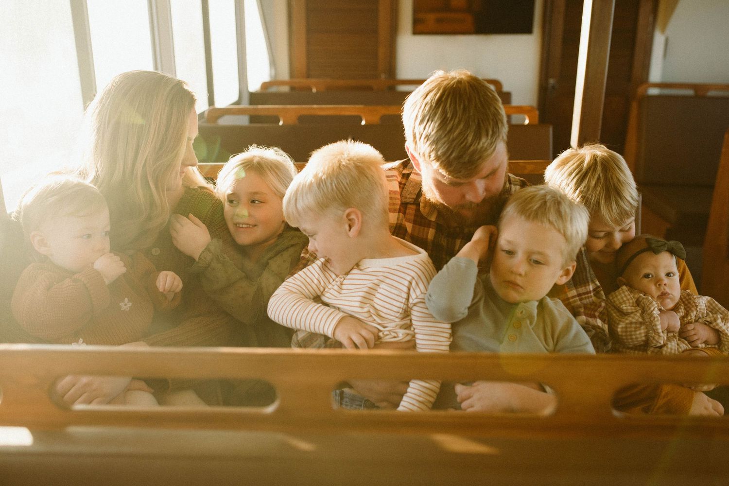 Family photo by B. Logsdon with the family on a boat illuminated by warm sunlight streaming through windows.