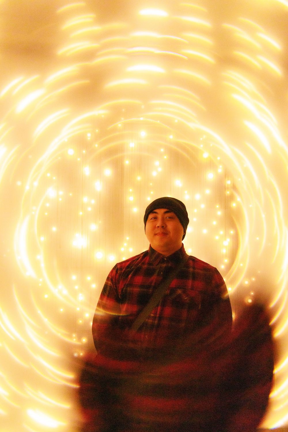 A person wearing a plaid shirt is shown in multiple poses against a glowing orange spiral light background effect.
