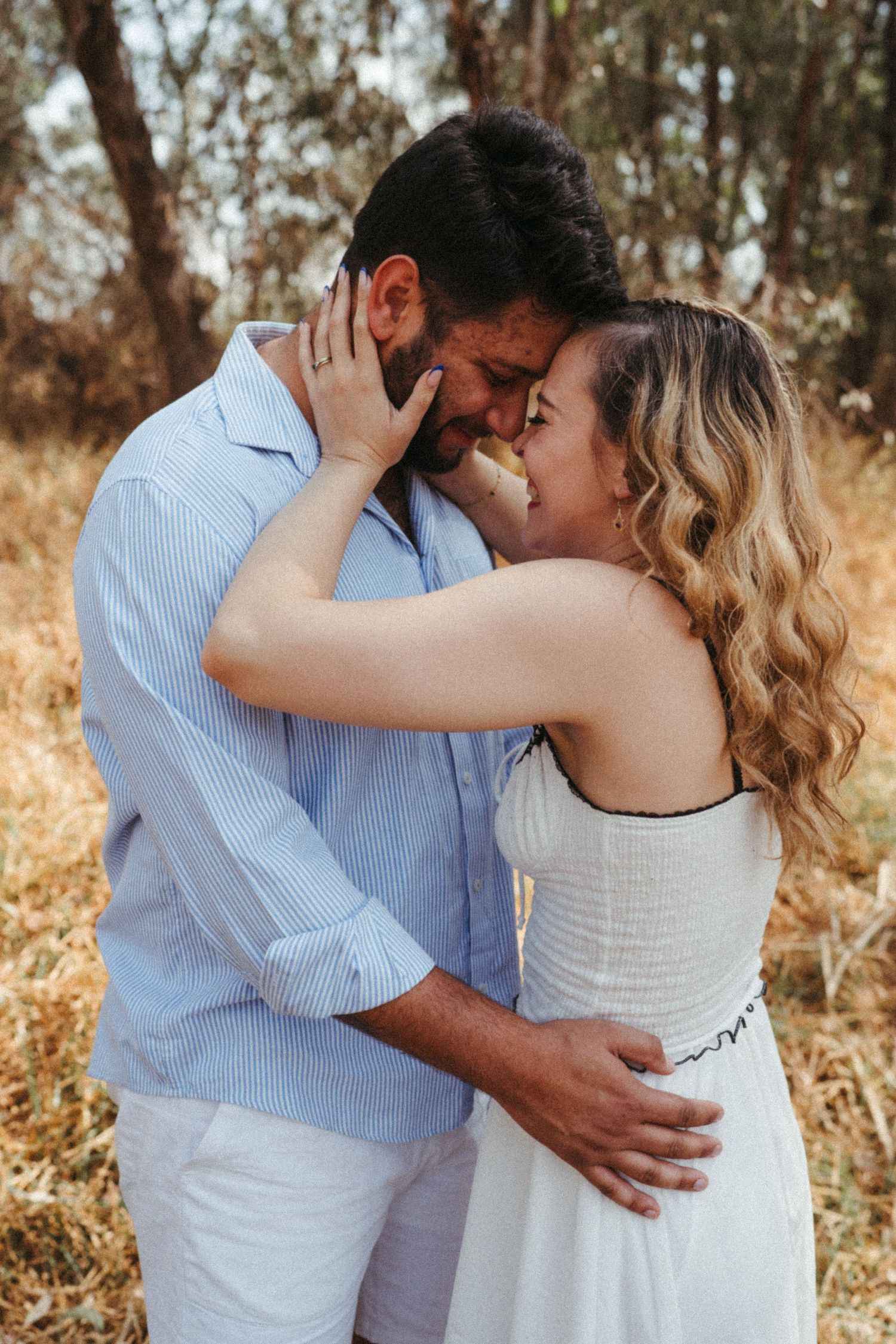 Close-up shot of couple sharing romantic moment in casual summer attire outdoors.
