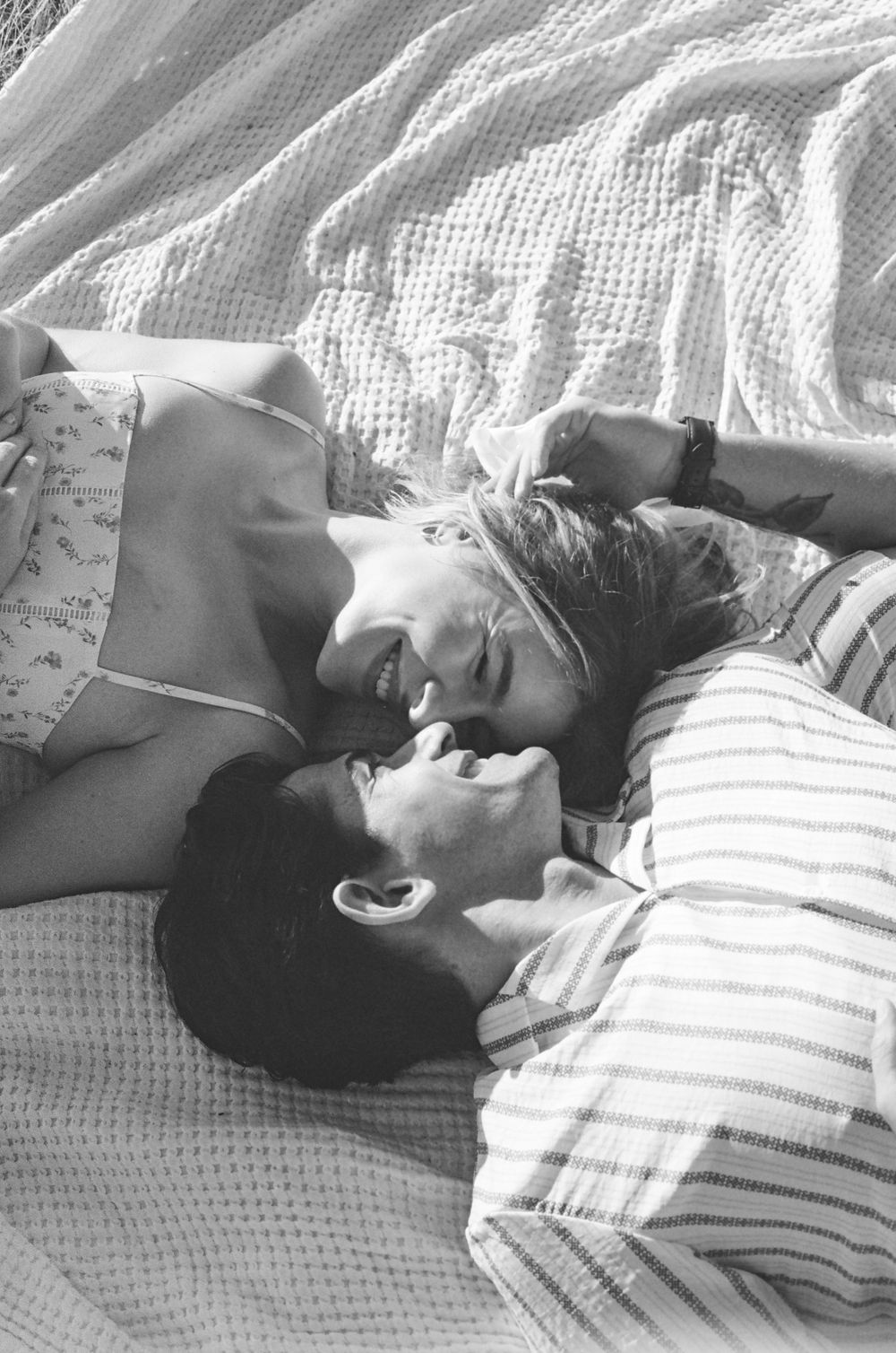 Black and white sequence of people resting together on pillows.