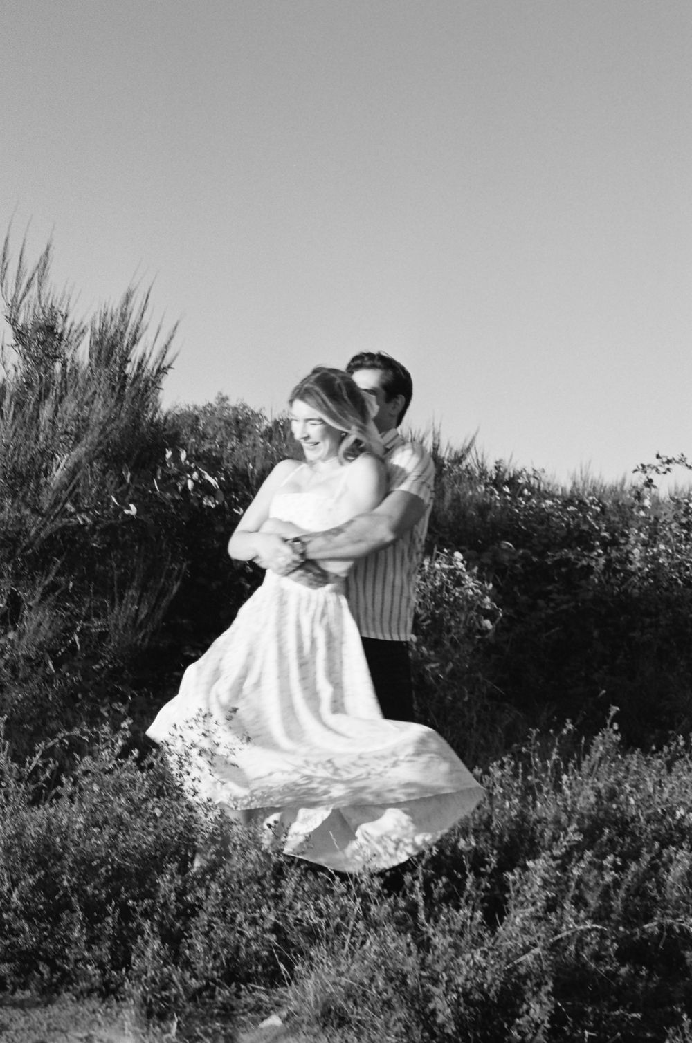 Black and white sequence of a couple dancing dramatically in an outdoor field.