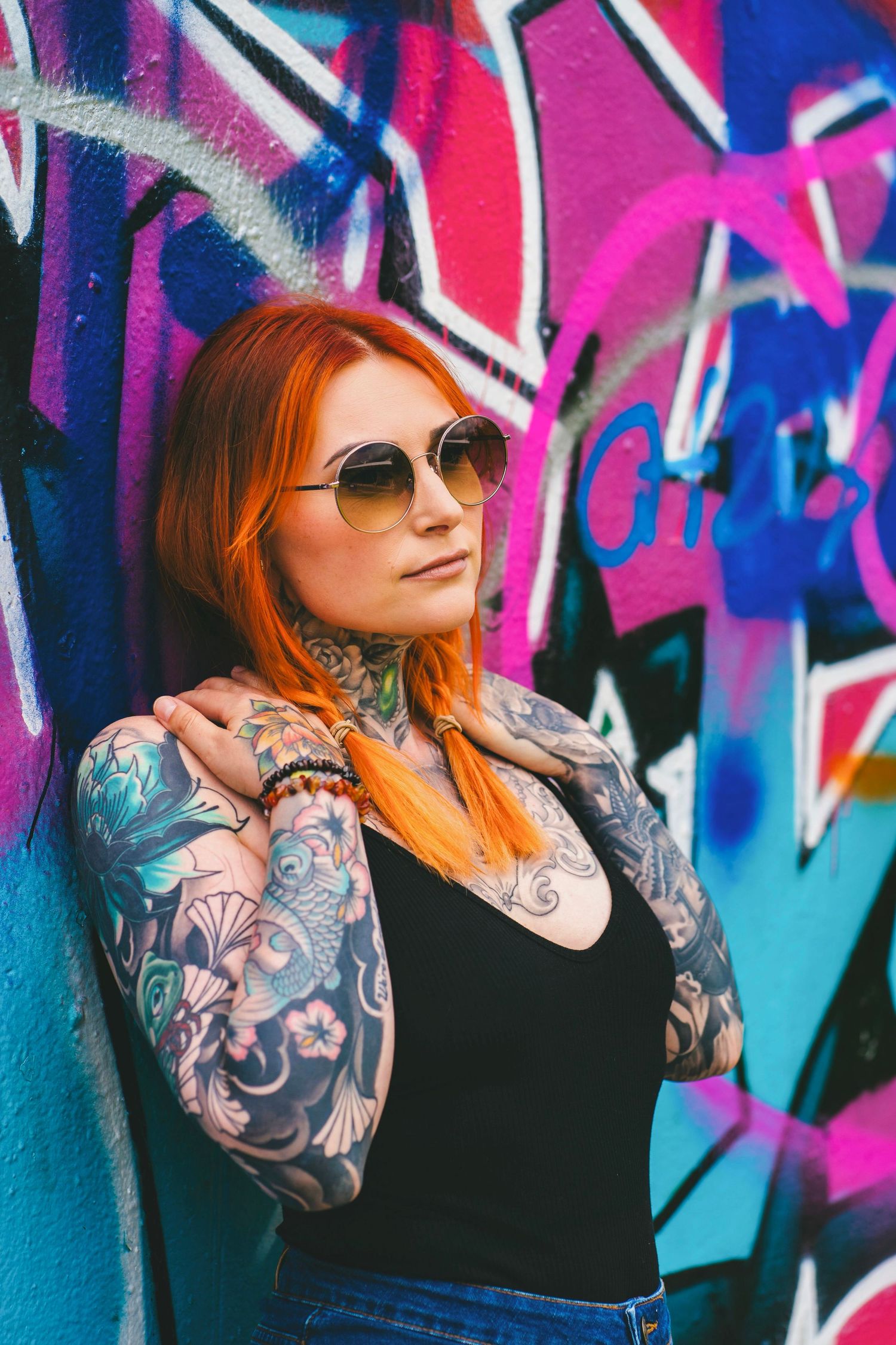 Porträtt av tatuerad kvinna i Halmstad – retrostil och graffitivägg. Fotograf från Malmö