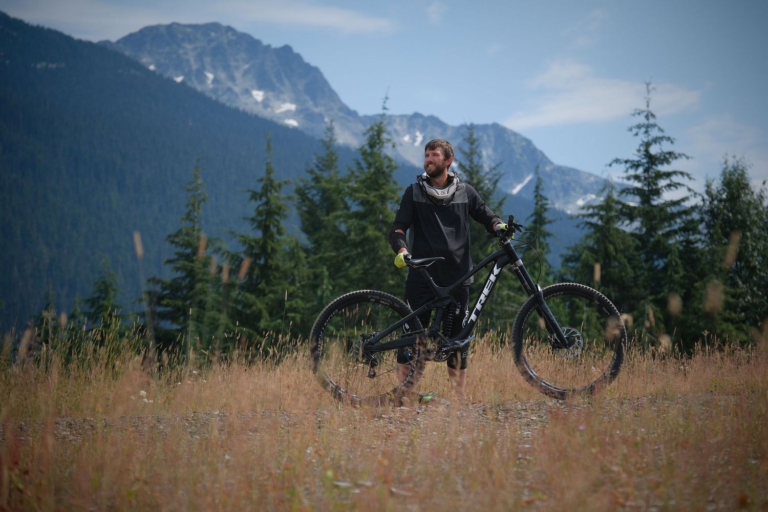 Mountain biker stands with bike against backdrop of mountainous landscape.
Whistler Mountain Bike Park