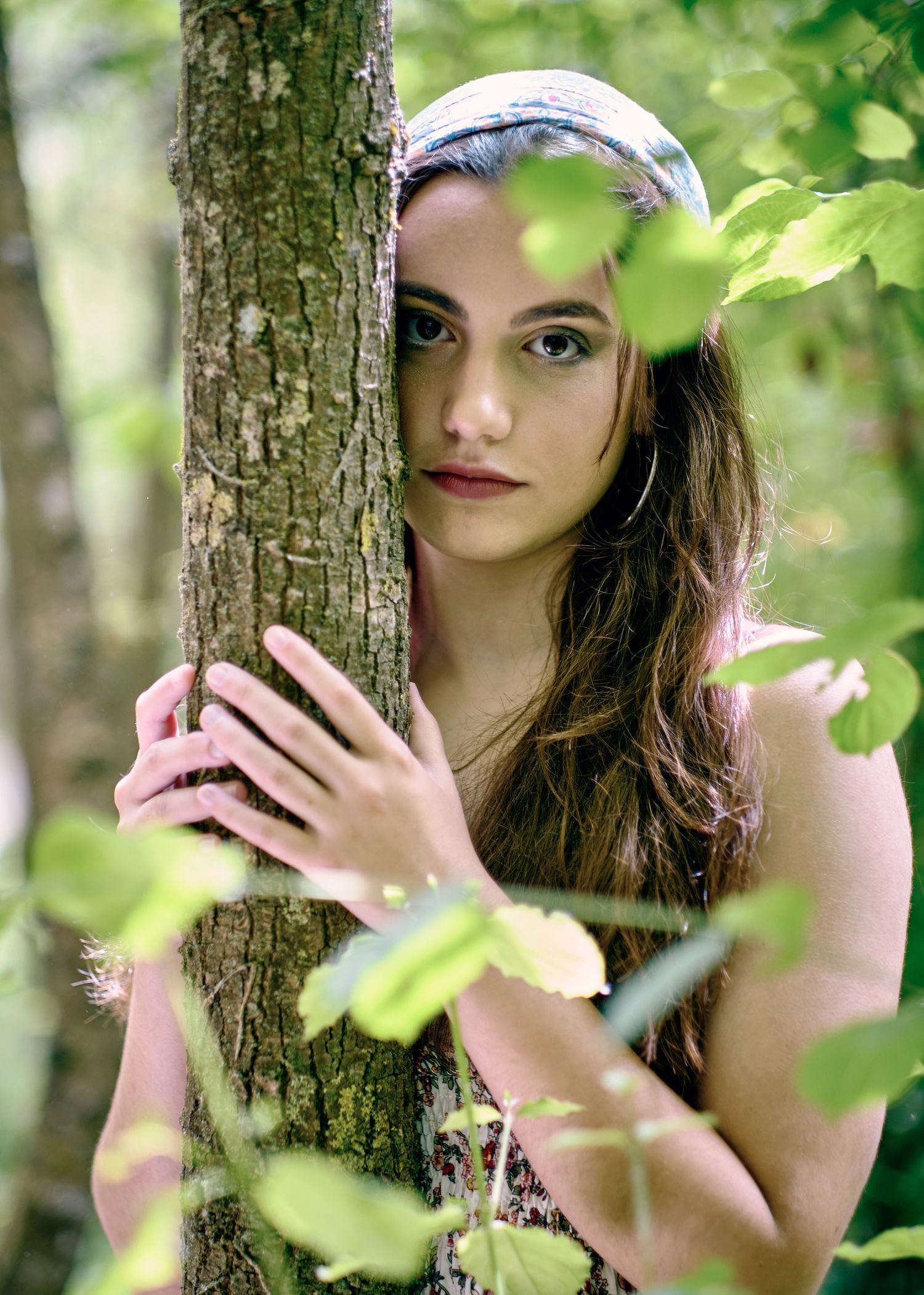 retrato intimista de una mujer joven entre las hojas de los arboles en un bosque