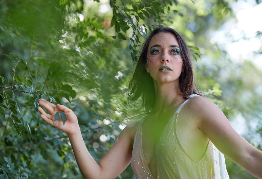 retrato etereo de una mujer joven entre las plantas del bosque