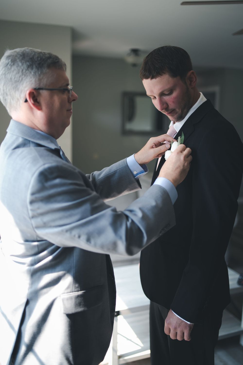 Two people in formal wear during a pre-wedding preparation moment.
