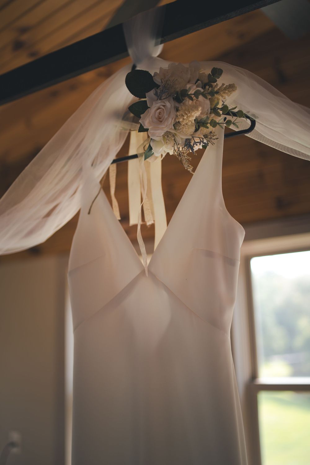 A close-up of a white wedding dress bodice with delicate floral bouquet detail.