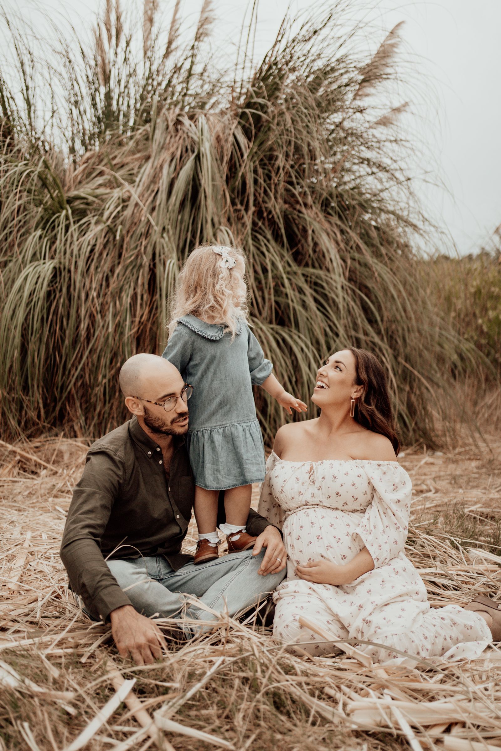 Joyful family photoshoot featuring natural expressions and interactions outdoors.
