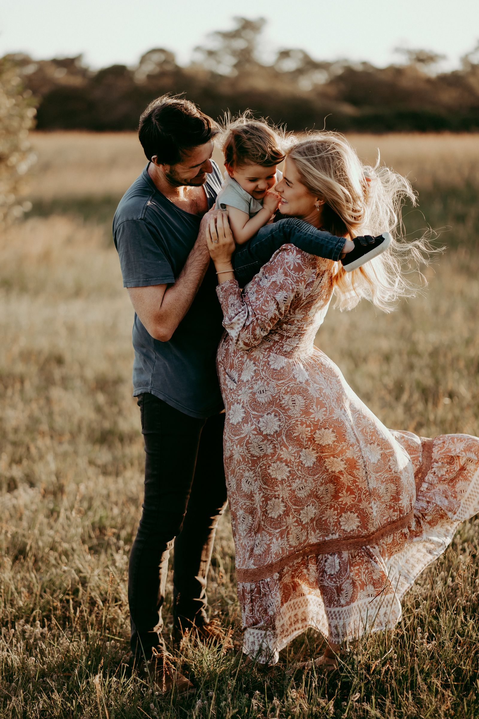 Couple sharing tender moments in a sunlit meadow during golden hour.