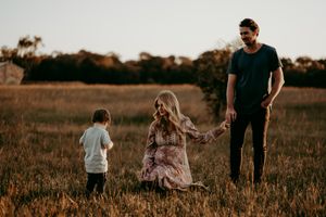 A family plays together in a sun-soaked field during golden hour.