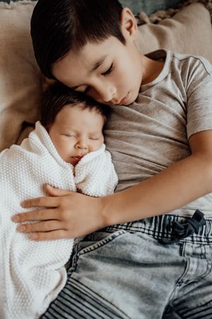 Child sleeping peacefully with white textured blanket.
