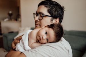 An intimate family portrait showing gentle support and comfort on a couch.