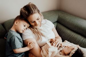 Intimate family moment sharing cuddles together on a green couch.