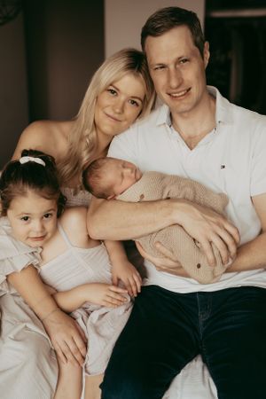 Family portrait on a couch showing tender embraces and love.