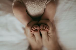 Close-up image of tiny baby feet against a soft white background.