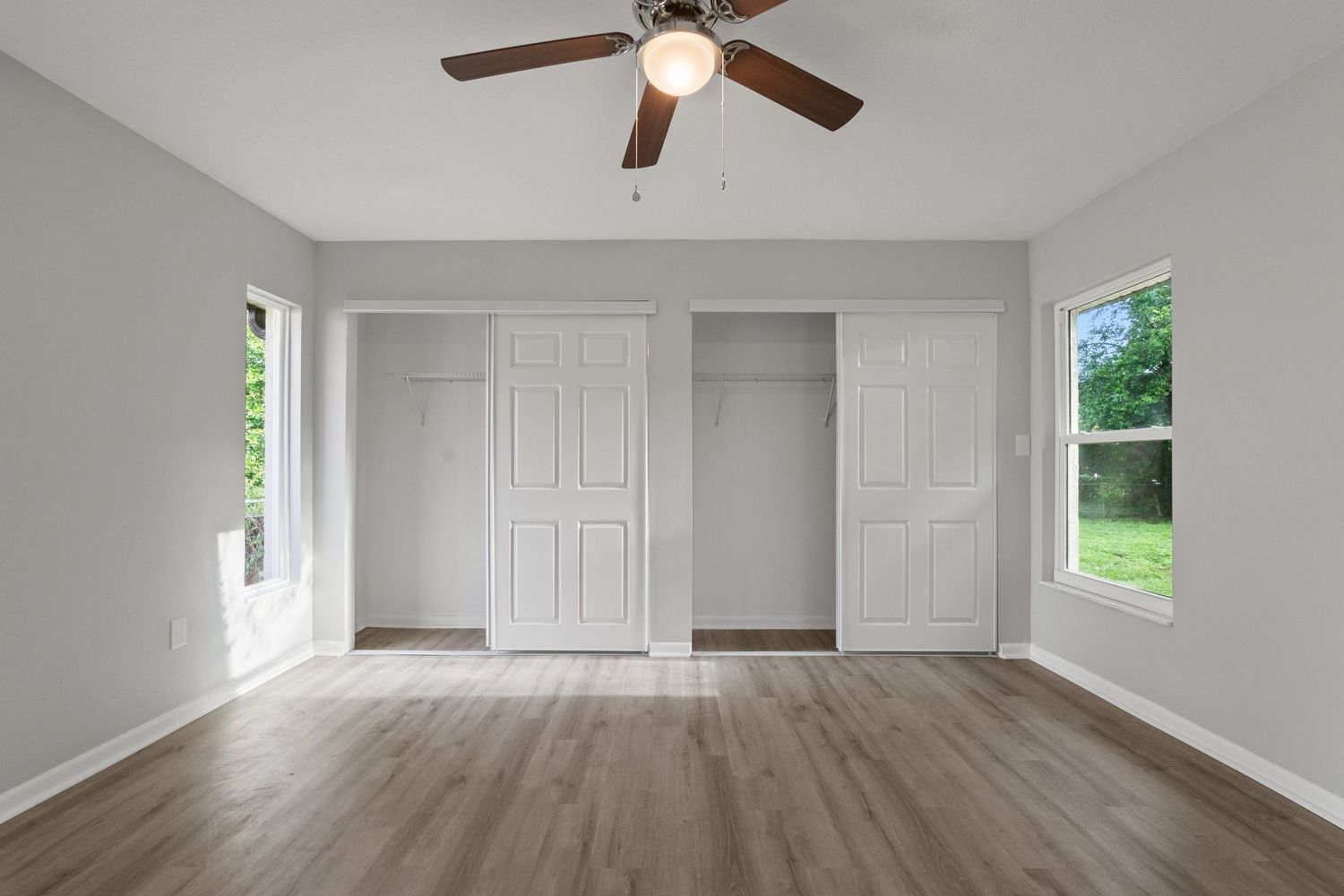 Elegant and bright master bedroom with large closet and hardwood floors.