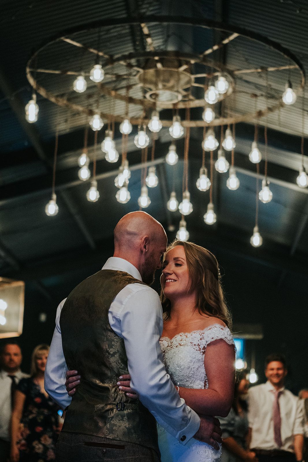 bride and groom dancing under a light fixture at Silchester farm wedding venue