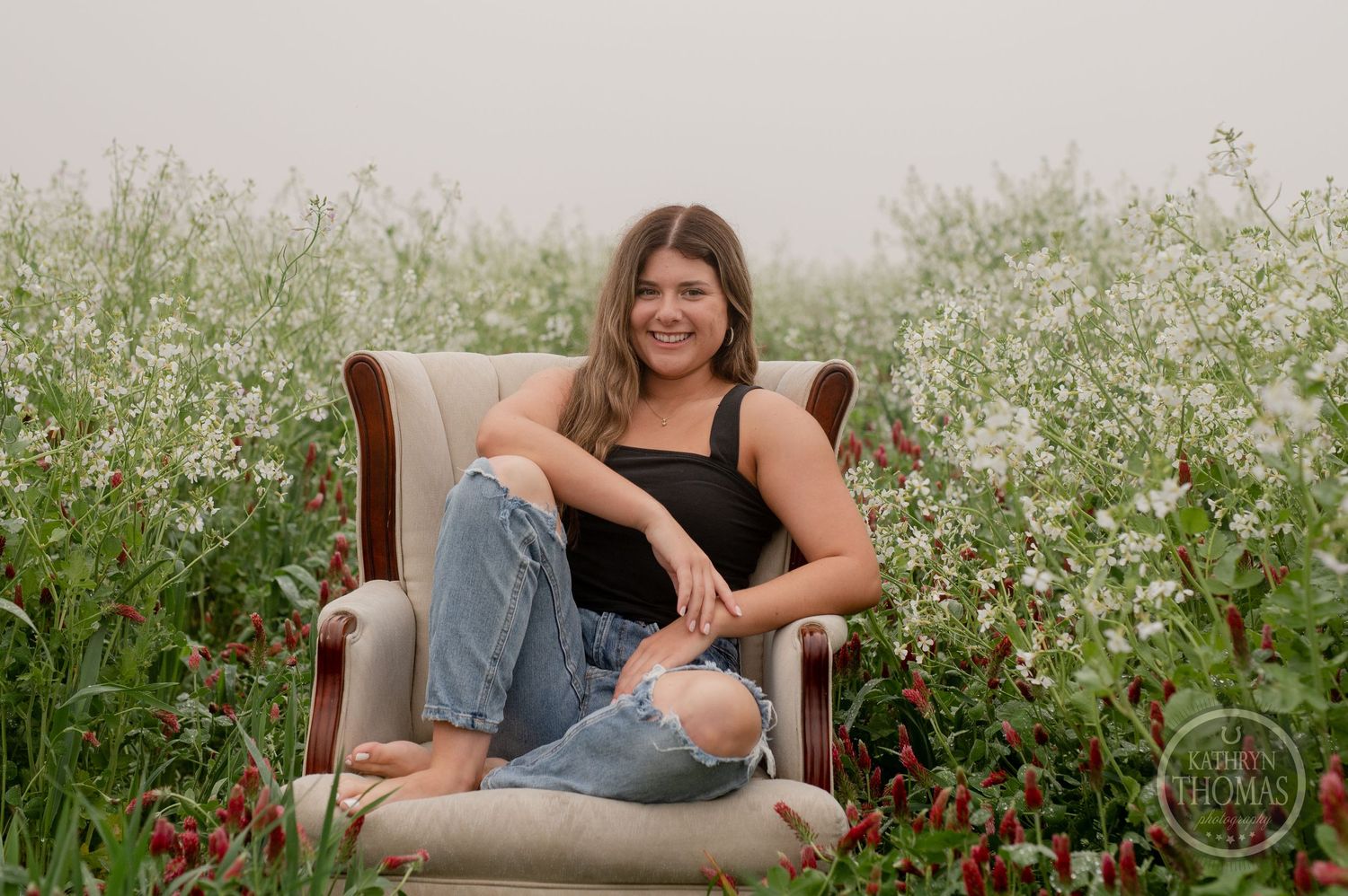Casual portrait session featuring ripped jeans and natural poses in a wildflower field.