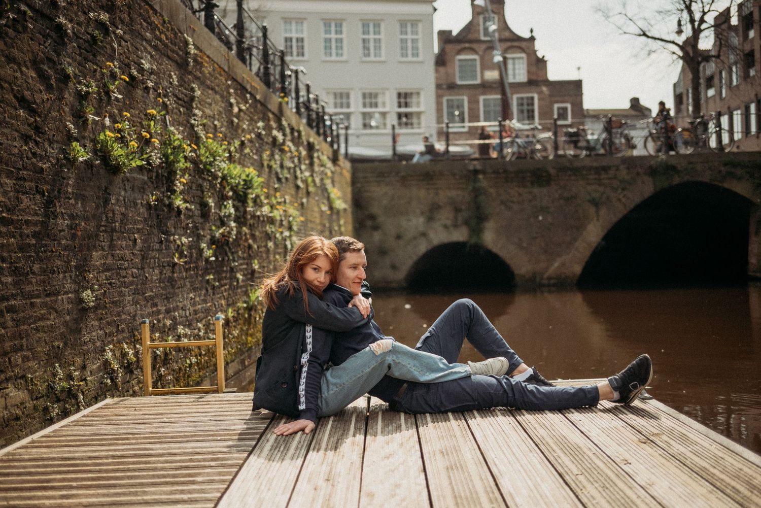 The couple sitting by the canal, enjoying a peaceful moment together.