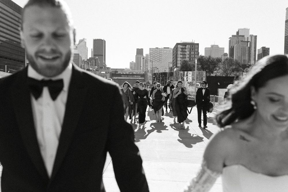 A series of black and white wedding photographs showing couples celebrating outdoors with city skylines in the background.