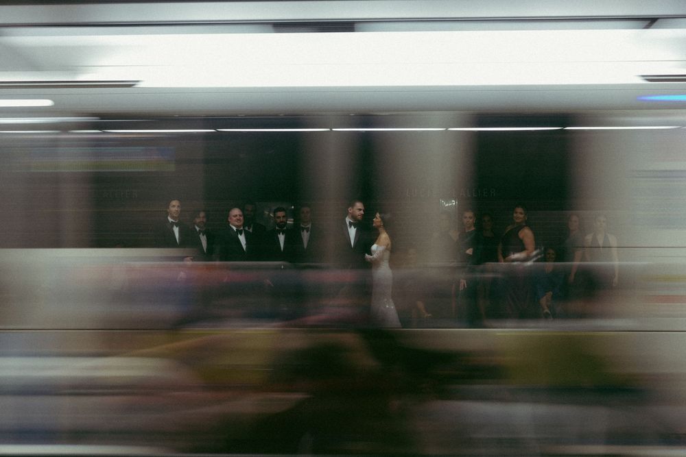 Blurred motion photograph showing people walking through a modern interior hallway or corridor.