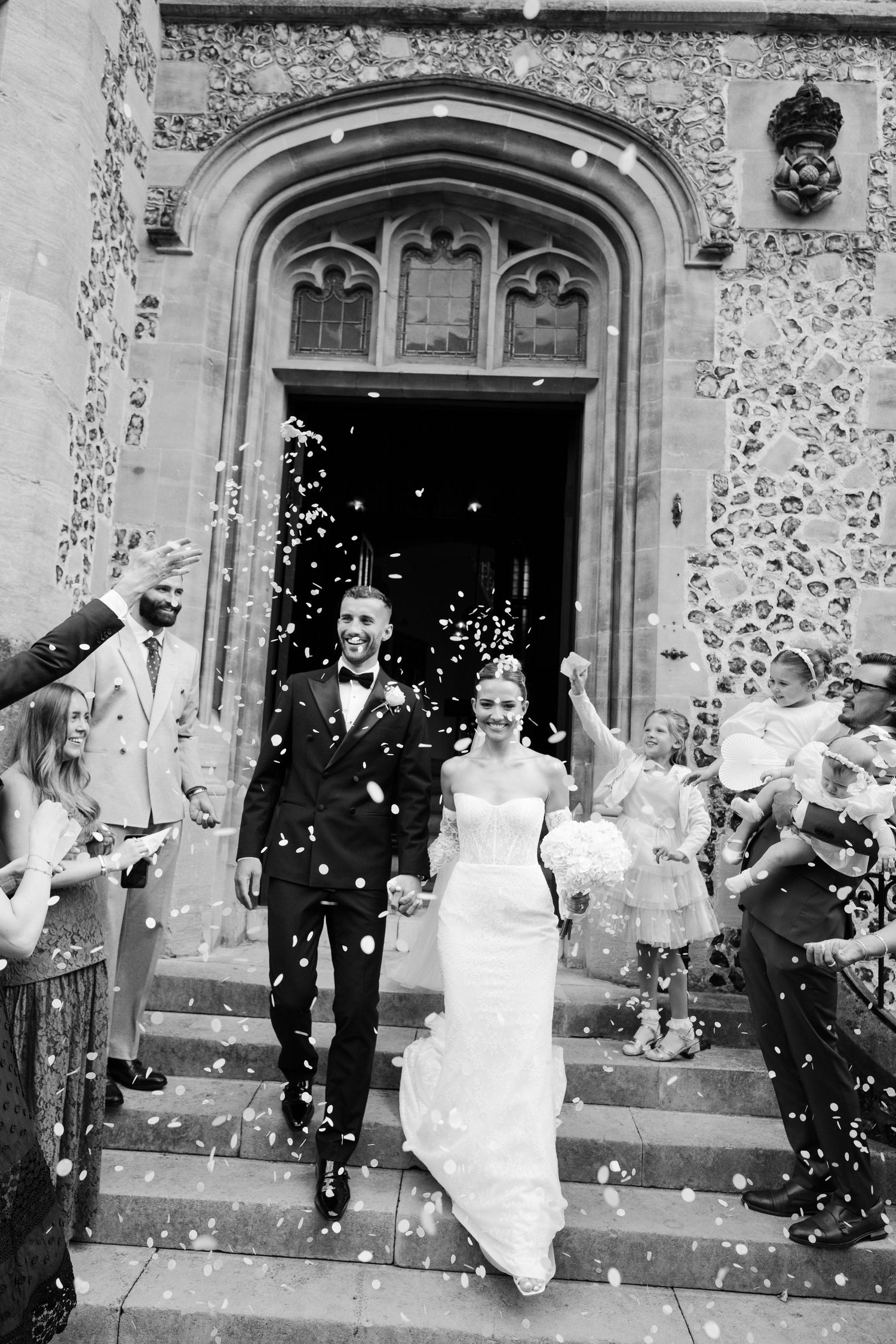 Bride and groom walk through confetti tunnel at Winchester registry office
